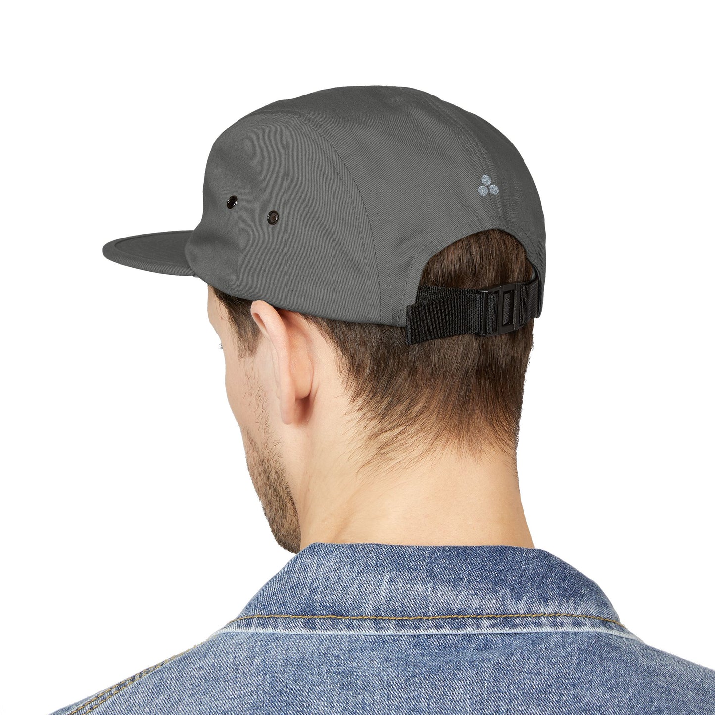 Person wearing a gray cap with a black strap on a white background. Mentally Elsewhere embroidered text design on five-panel cap. TEEZOCA