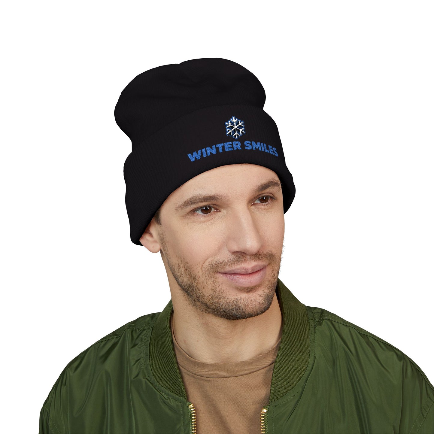 Man wearing a black beanie with 'Winter Smiles' text on a white background. Minimalist embroidered winter hat with cheerful seasonal design