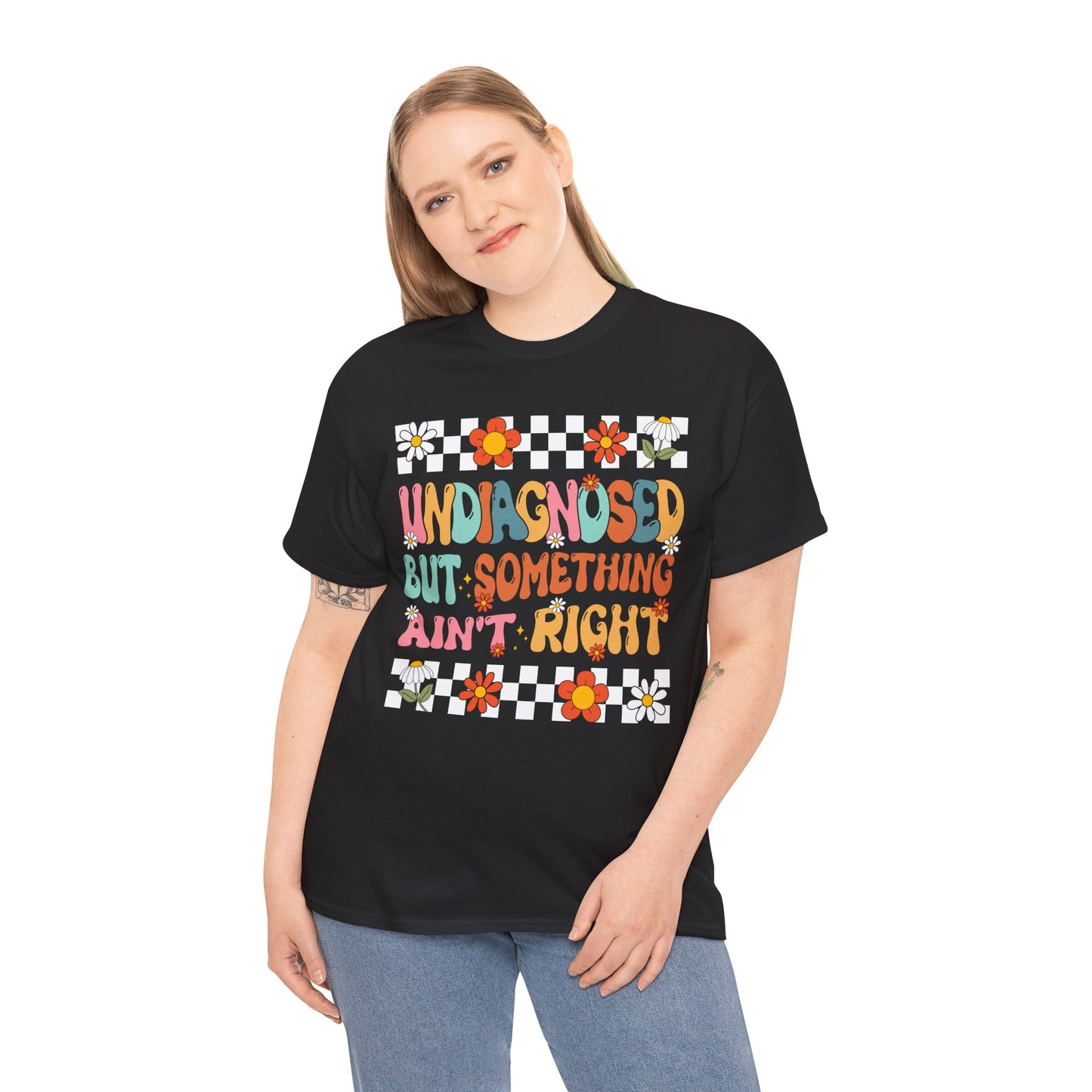 Person wearing a black t-shirt with colorful text and flower designs on a white background