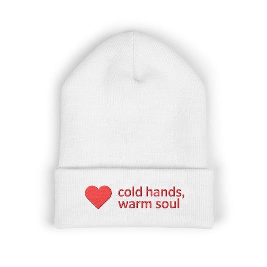 White beanie with a red heart and text 'cold hands, warm soul' on a white background