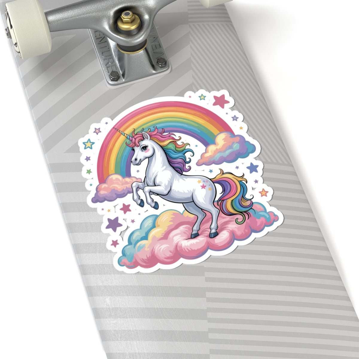 Skateboard with a unicorn and rainbow sticker on a gray background. TEEZOCA