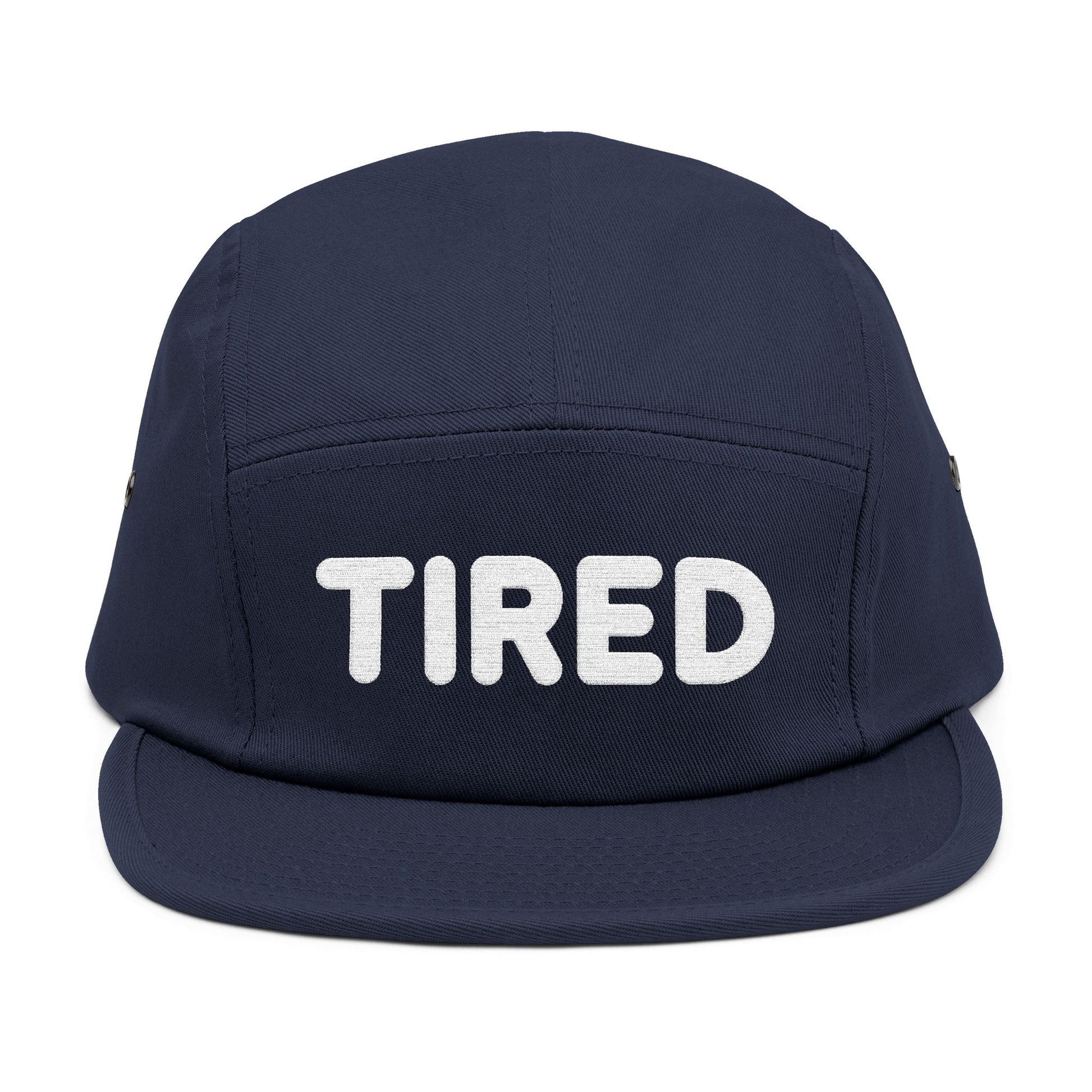 Navy blue cap with 'TIRED' text on a white background. TIRED minimalist text embroidered on 5-panel cap by TEEZOCA