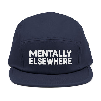 Navy blue cap with 'MENTALLY ELSEWHERE' text on a white background. Mentally Elsewhere embroidered text design on five-panel cap. TEEZOCA