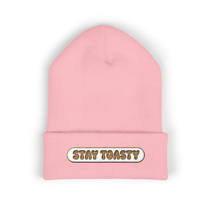 Pink beanie with 'Stay Toasty' text on a white background