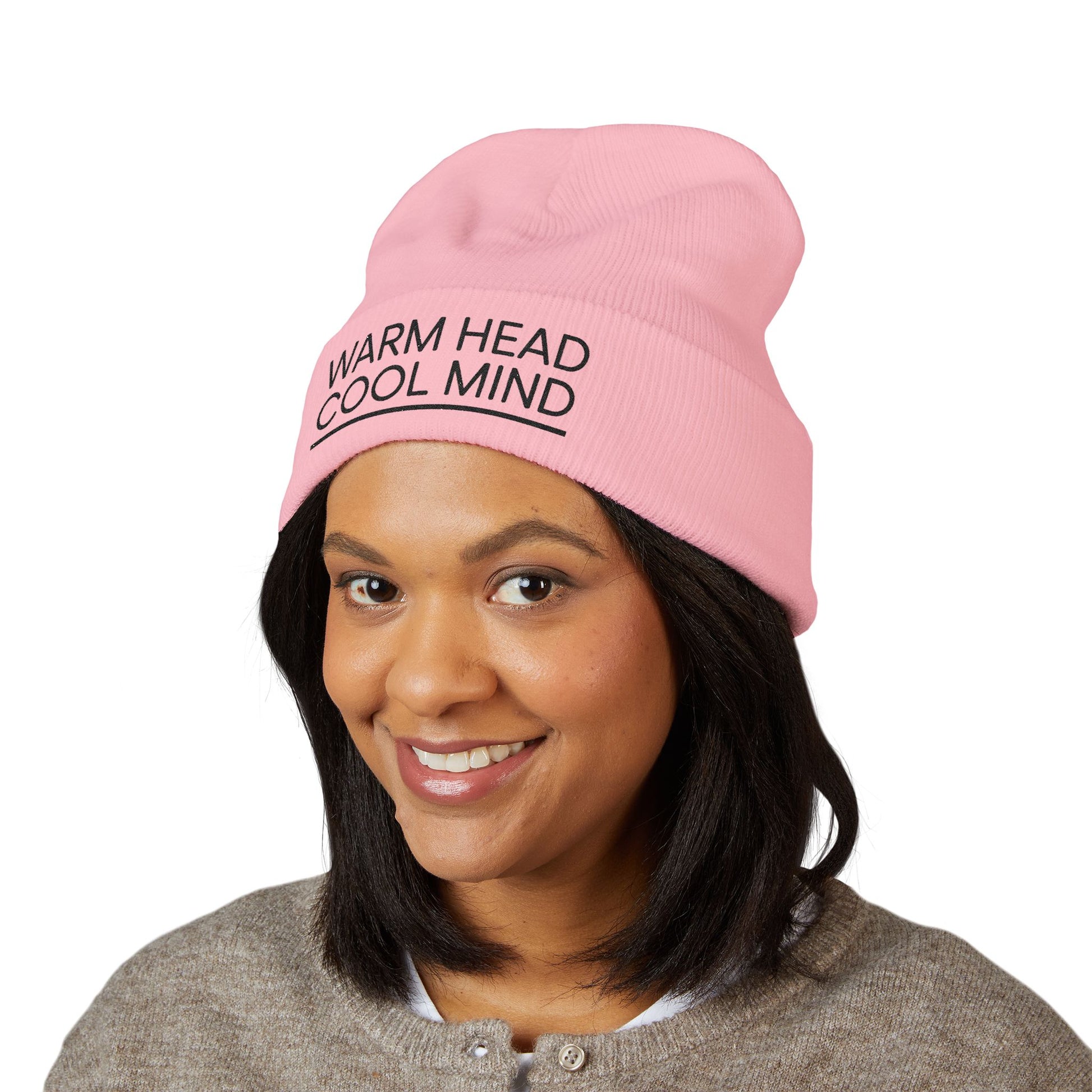 Person wearing a pink beanie with 'Warm Head Cool Mind' text on a white background. Warm Head Cool Mind embroidered beanie in minimalist black lettering