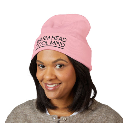 Person wearing a pink beanie with 'Warm Head Cool Mind' text on a white background. Warm Head Cool Mind embroidered beanie in minimalist black lettering