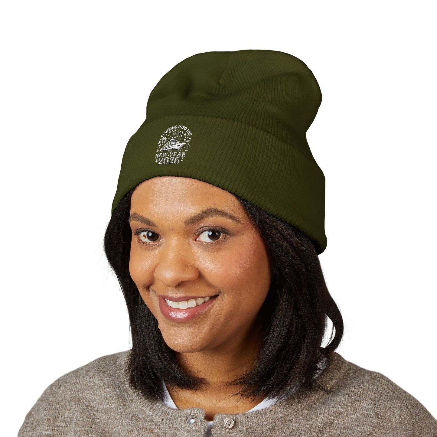 Person wearing a green beanie with a cruising into the new year 2026 design on a white background