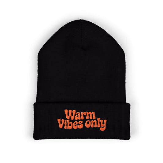 Black beanie with 'Warm Vibes only' text in orange on a white background. “Warm vibes only” embroidered patch on cozy cuffed beanie in retro orange thread.