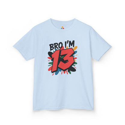  Light blue kids’ t‑shirt with “Bro I’m 13” graffiti text, big red 13, and multicolor paint splash, flat front view.