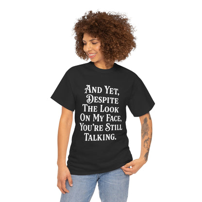 “Female model wearing Teezoca And Yet Despite the Look on My Face You’re Still Talking t-shirt, sarcastic quote design, black unisex tee, front.”


