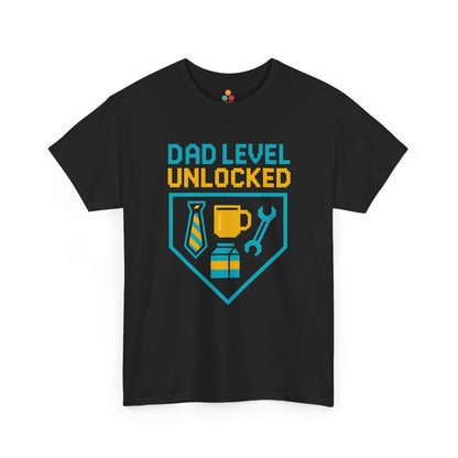 "Black t‑shirt with teal and gold achievement badge shield featuring tie, coffee cup, and wrench icons with the text 'DAD LEVEL UNLOCKED,' flat front view."

