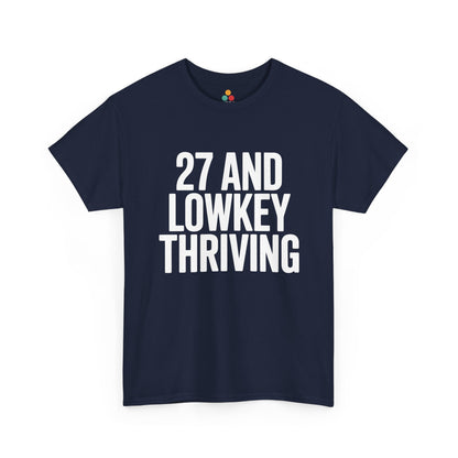 Navy blue t-shirt with white text '27 AND LOWKEY THRIVING' on a white background