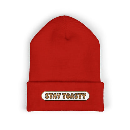 Red beanie with 'Stay Toasty' label on a white background