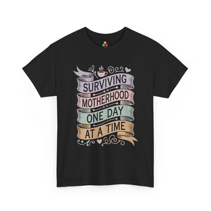 TEEZOCA black "Surviving Motherhood One Day At A Time" vintage banner graphic t‑shirt shown flat.