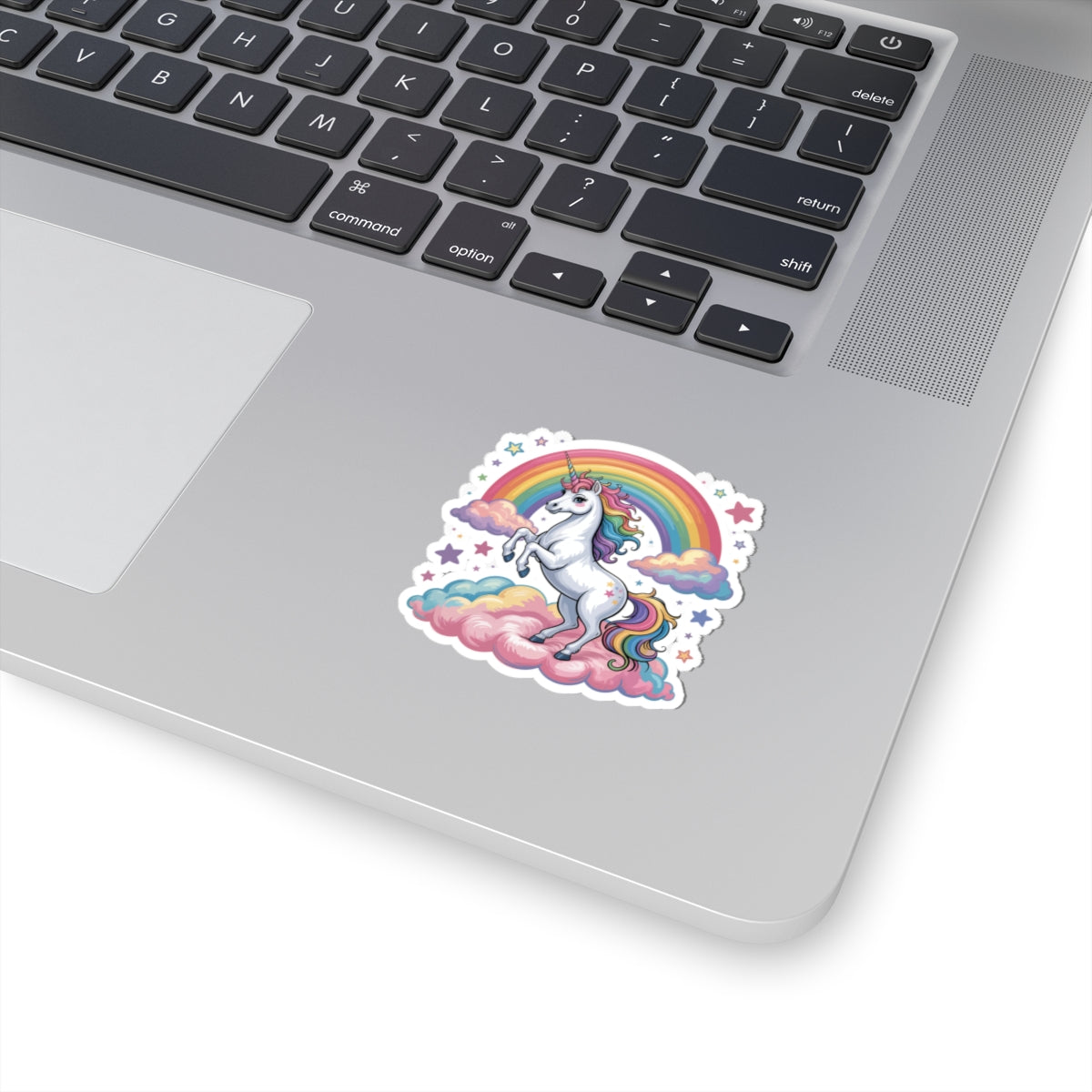 Laptop with a colorful unicorn sticker featuring a rainbow on a white background. TEEZOCA
