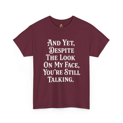 “Teezoca And Yet Despite the Look on My Face You’re Still Talking shirt, funny sarcasm quote in white text, maroon tee, flat front display.”

