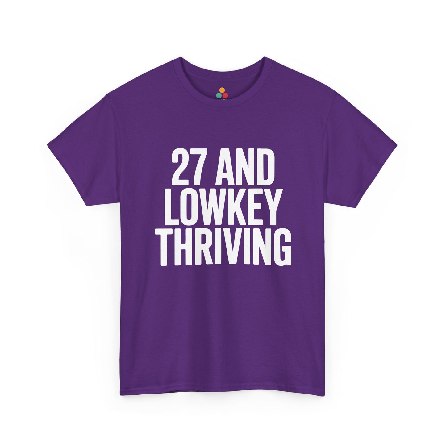 Purple t-shirt with white text '27 AND LOWKEY THRIVING' on a white background