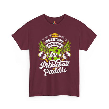 “Teezoca maroon Never Underestimate an Old Man with a Pickleball Paddle shirt, green pickleball with wings and paddles, funny gift for pickleball grandpa, front.”

