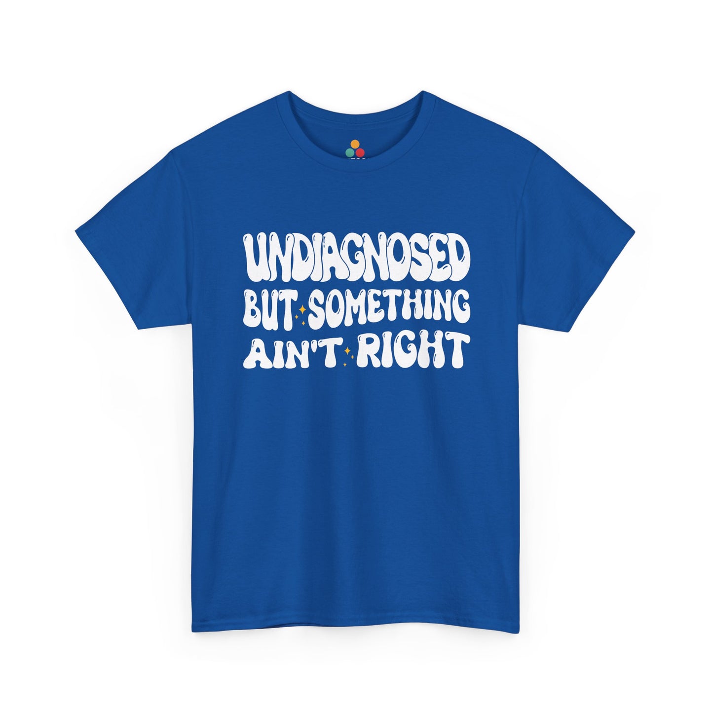 “Teezoca Undiagnosed But Something Ain’t Right t-shirt, bold white bubble text with tiny yellow sparkles, royal blue tee, front.”​


