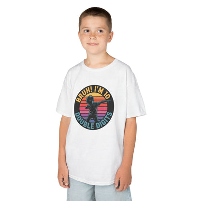 “Boy wearing white ‘Bruh! I’m 10 Double Digits’ 10th birthday shirt, dab pose graphic with retro sunset circle, front view.”

