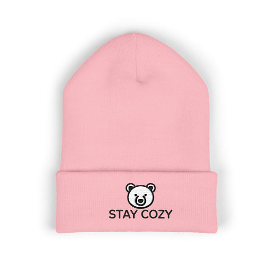 Pink beanie with 'Stay Cozy' text and bear logo on a white background