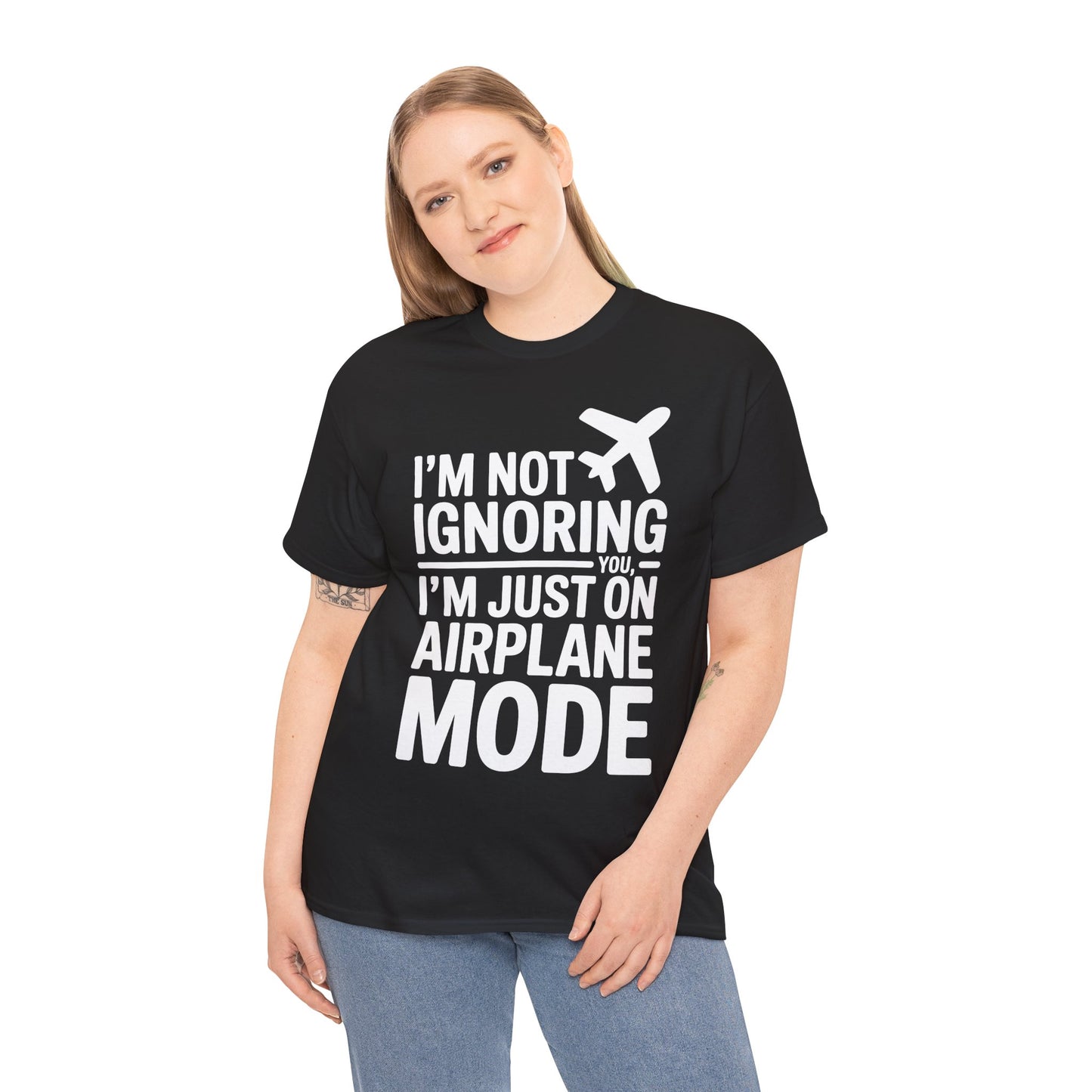 Person wearing a black t-shirt with " I'm Not Ignoring You, I'm Just On Airplane Mode " text and an airplane graphic on a white background | TEEZOCA