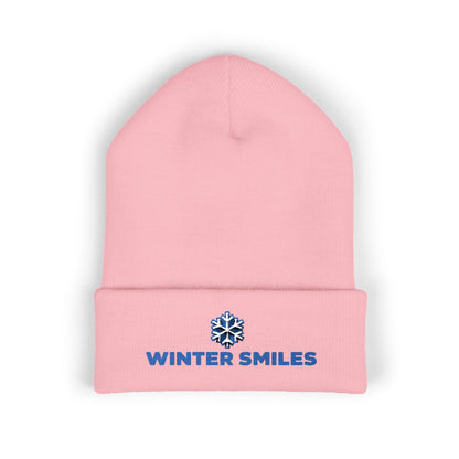 Pink beanie with 'Winter Smiles' logo on a white background. Close-up of snowflake embroidery on cozy winter knit hat