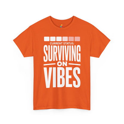 Orange t-shirt with 'Current Status: Surviving on Vibes' text on a white background | TEEZOCA