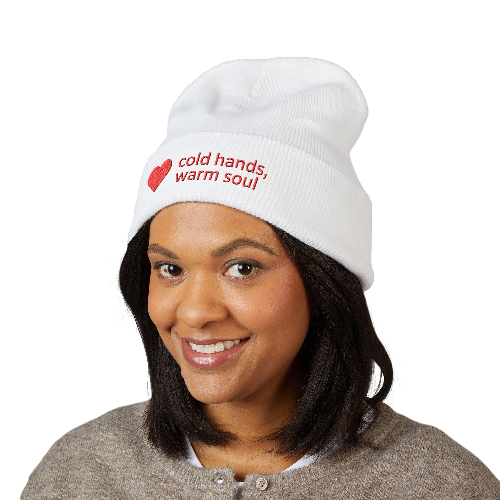 Person wearing a white beanie with 'cold hands, warm soul' text and a red heart on a white background