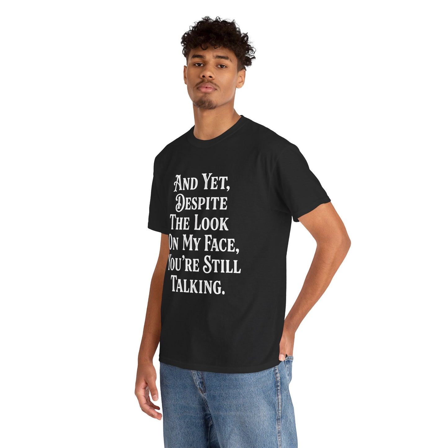 “Male model in Teezoca And Yet Despite the Look on My Face You’re Still Talking shirt, white stacked typography, black tee, casual pose.”


