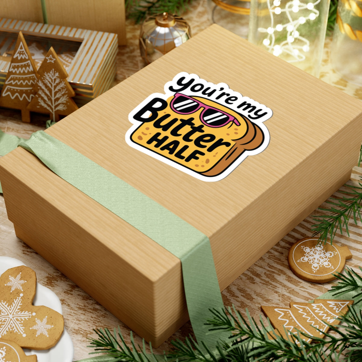 Wooden gift box with a 'you're my Butter Half' sticker on a festive background with cookies and lights. TEEZOCA