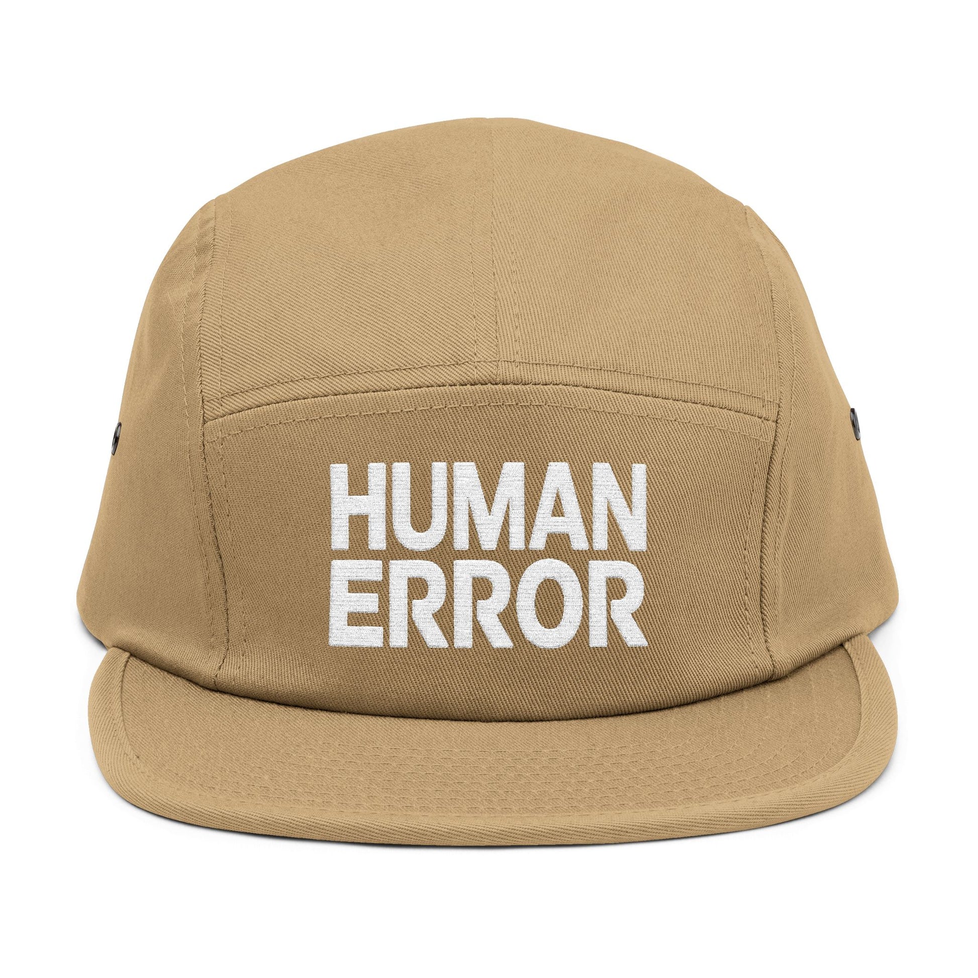 Tan cap with 'HUMAN ERROR' text on a white background. Front view of an embroidered 5-panel cap featuring the bold “HUMAN ERROR” typography in white. TEEZOCA