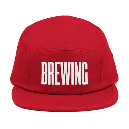 Red cap with 'BREWING' text on a white background. BREWING minimalist text embroidery design on 5-panel cap. TEEZOCA