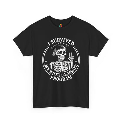Black TEEZOCA t‑shirt with “I Survived My Wife’s Doctorate Program” skeleton graduation graphic shown flat.
