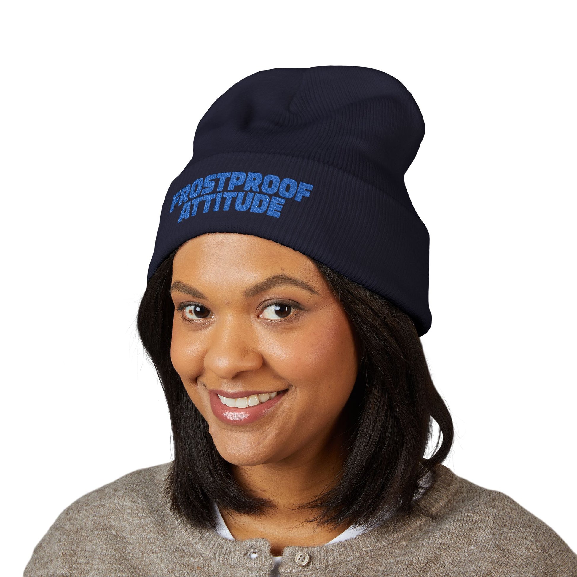 Person wearing a navy blue beanie with 'Frostproof Attitude' text embroidered
