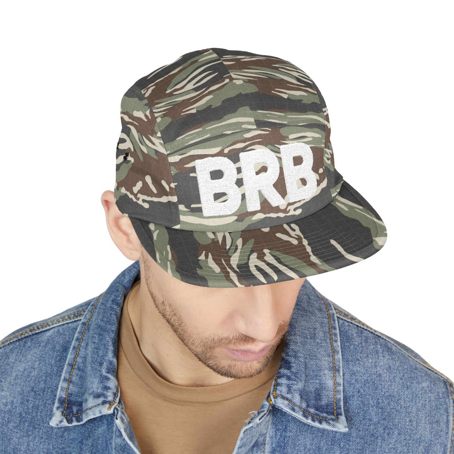 Camouflage bucket hat with 'BRB' text worn by a person on a white background. Bold BRB design optimized for stitched detailing. TEEZOCA
