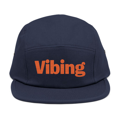 Navy blue cap with 'Vibing' in orange on a white background. Close-up of “Vibing” premium embroidery for streetwear style. TEEZOCA