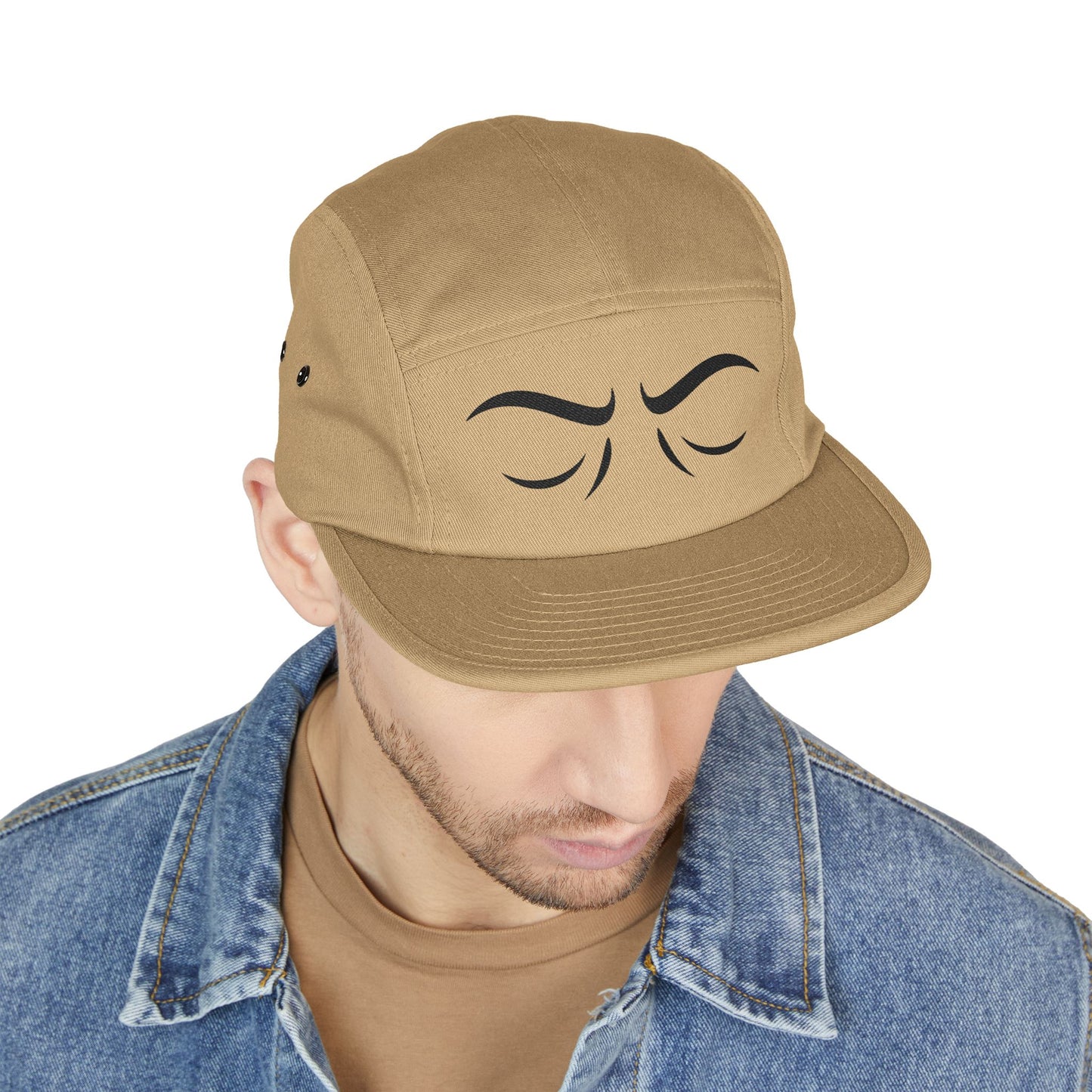 Man wearing a tan cap with a unique design on a white background. Subtle expressive eyes embroidery artwork. TEEZOCA