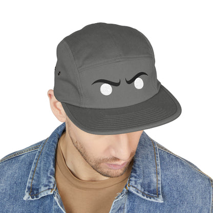 Person wearing a gray cap with cartoonish eyes and a mustache on a white background. Simple embroidered angry eyes artwork for hats and accessories. TEEZOCA