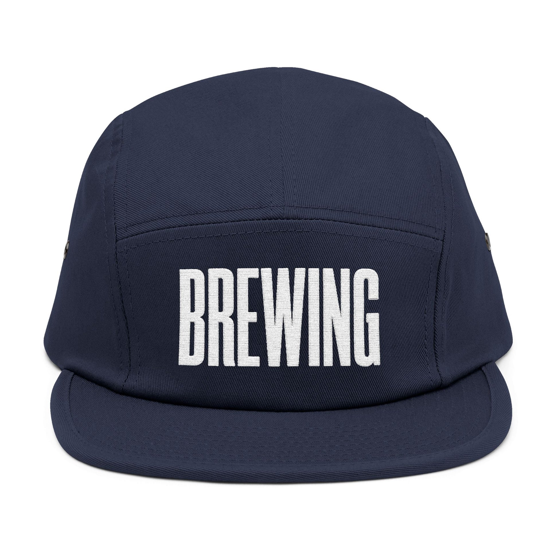 Navy blue cap with 'BREWING' text on a white background. BREWING minimalist text embroidery design on 5-panel cap. TEEZOCA