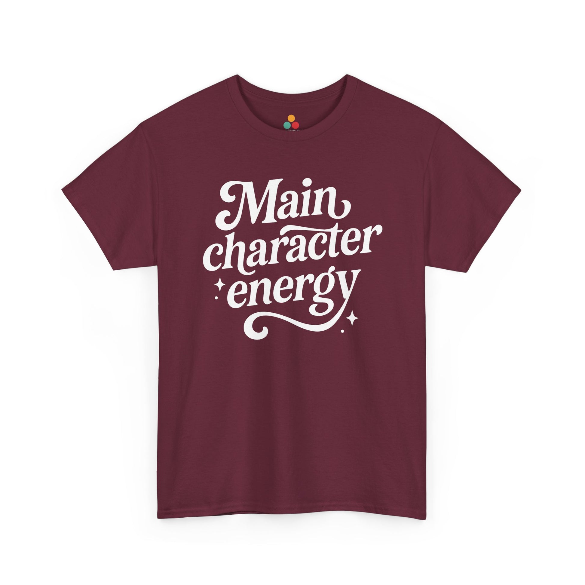 “Teezoca Main Character Energy shirt, white script and sparkles design, maroon tee, flat front display.”

