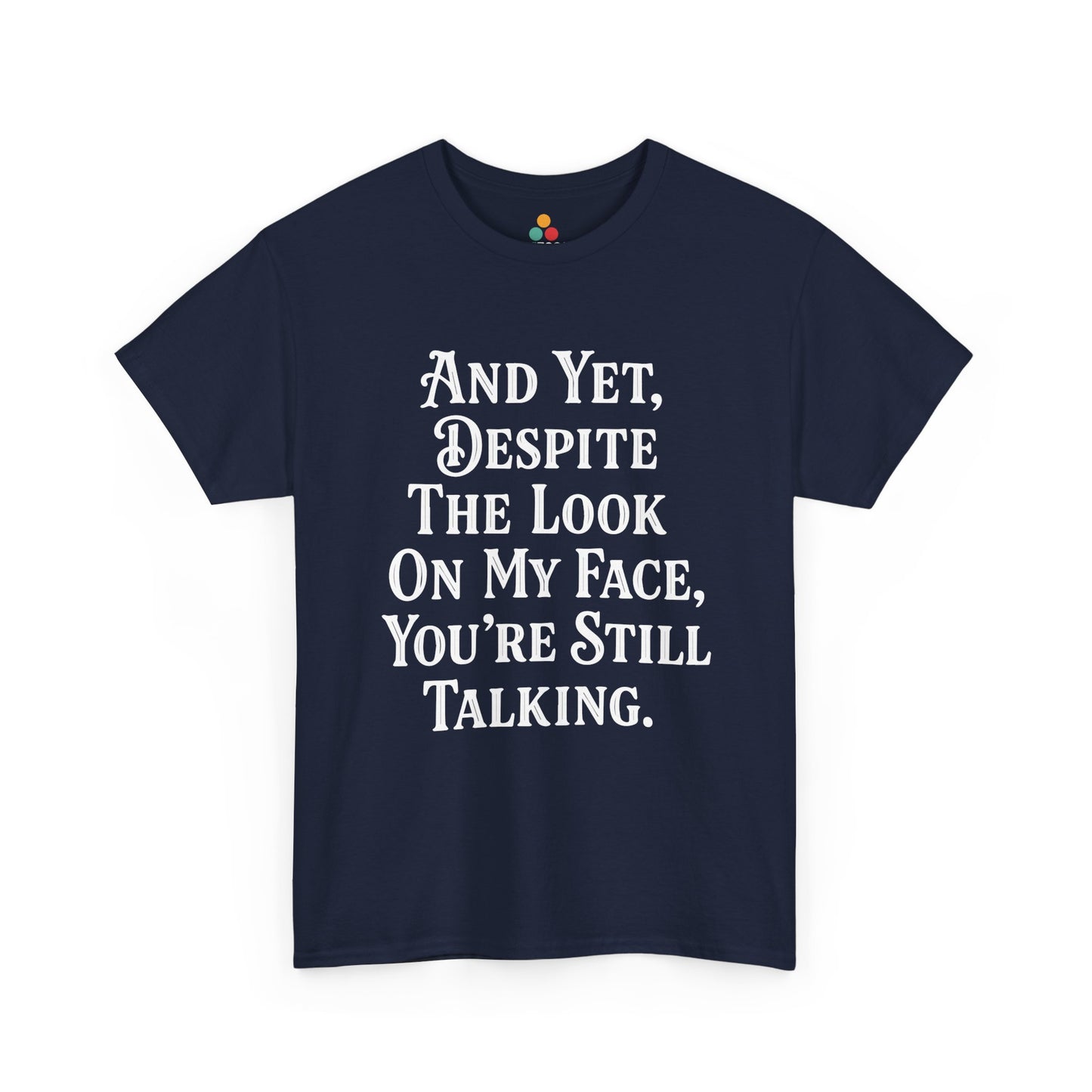 “Teezoca And Yet Despite the Look on My Face You’re Still Talking t-shirt, minimalist sarcasm typography, navy blue tee, front view.”

