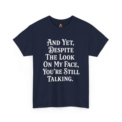 “Teezoca And Yet Despite the Look on My Face You’re Still Talking t-shirt, minimalist sarcasm typography, navy blue tee, front view.”

