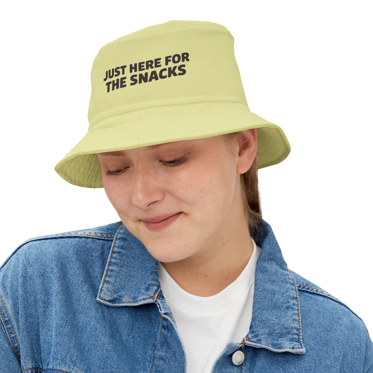 Funny sarcastic light green bucket hat with text 'JUST HERE FOR THE SNACKS' on a white background. TEEZOCA