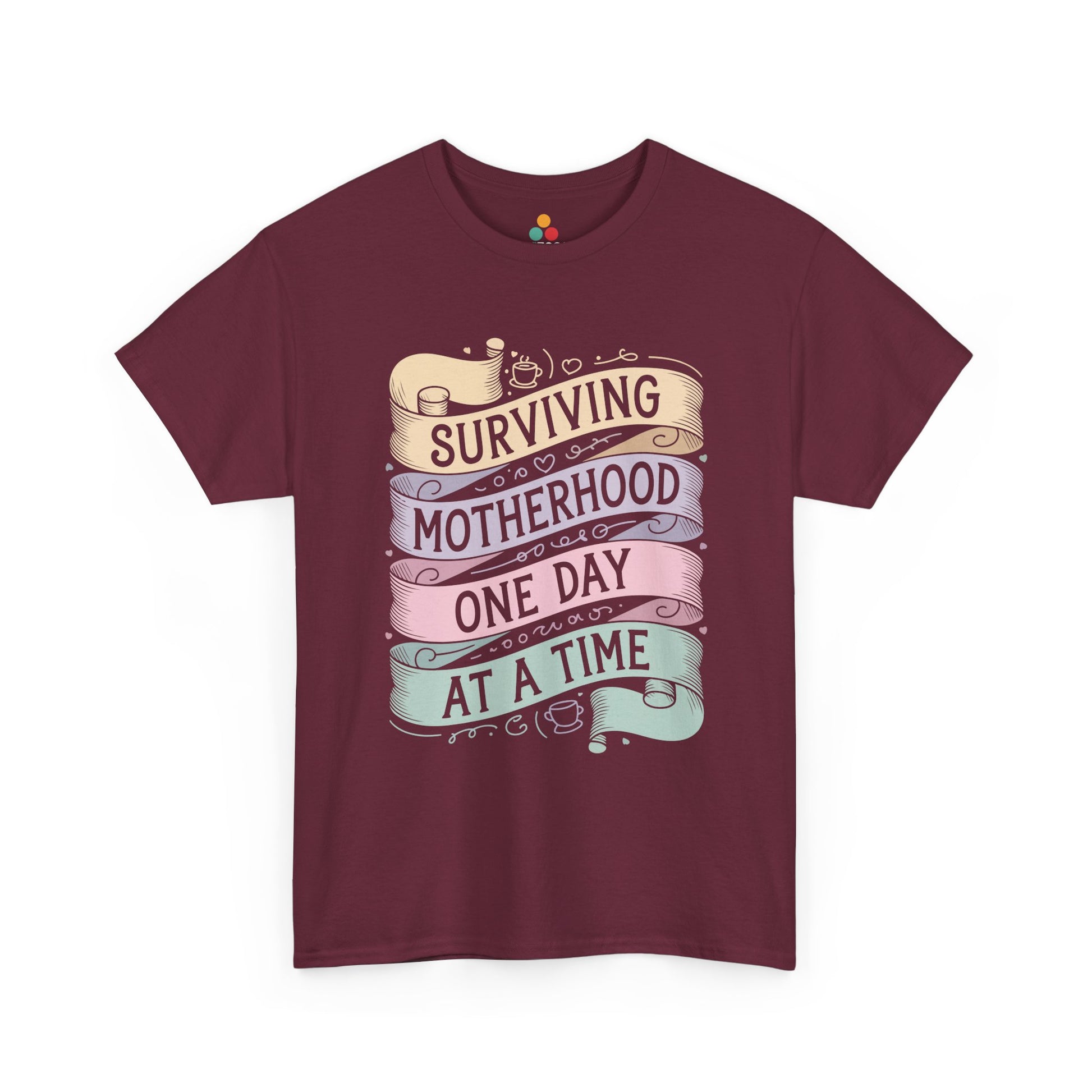 TEEZOCA maroon “Surviving Motherhood One Day At A Time” pastel ribbon graphic tee displayed flat.