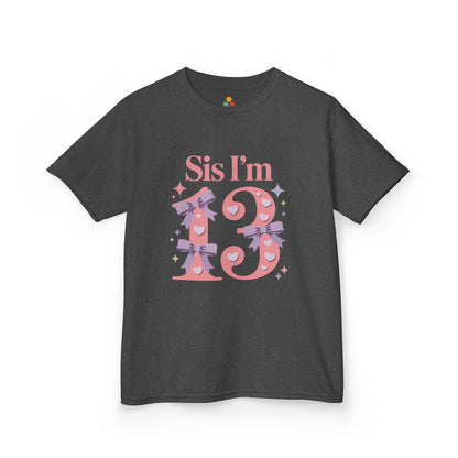 Charcoal grey t‑shirt with pink “Sis I’m 13” design featuring hearts, lilac bows, and sparkles, flat front view.