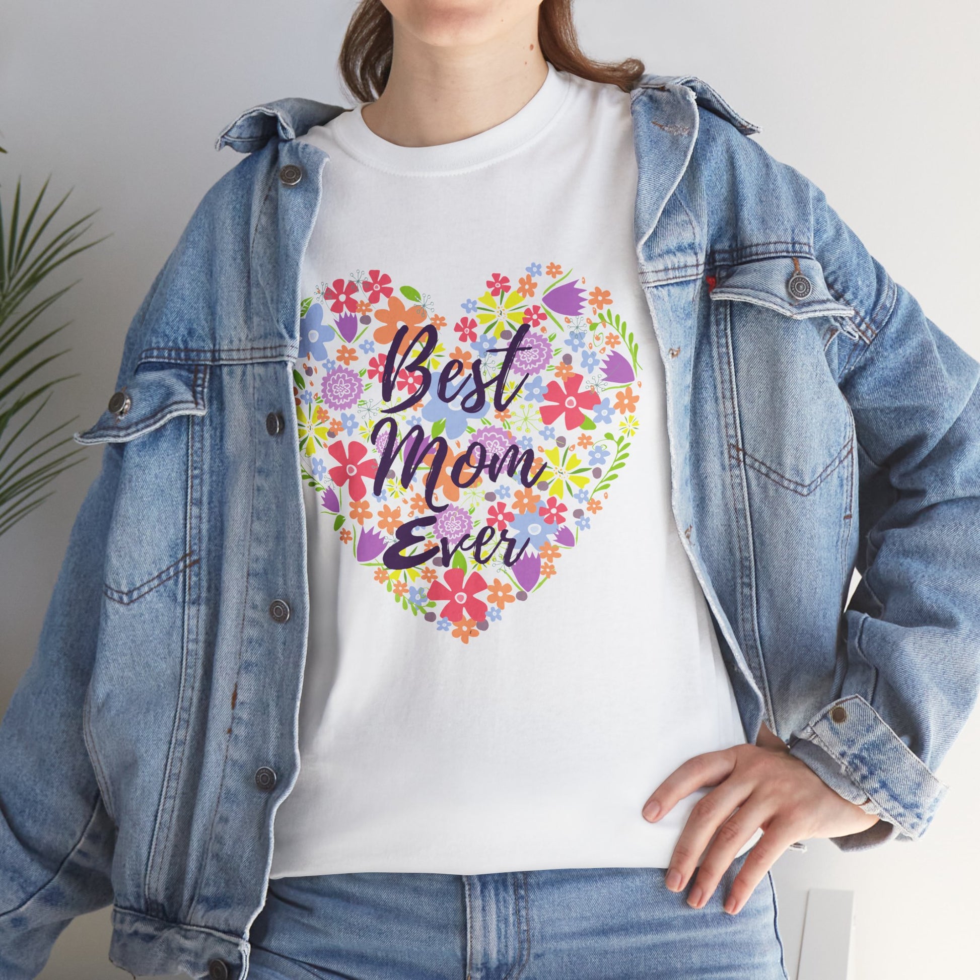 Woman wearing a white TEEZOCA “Best Mom Ever” flower heart tee styled with a denim jacket.