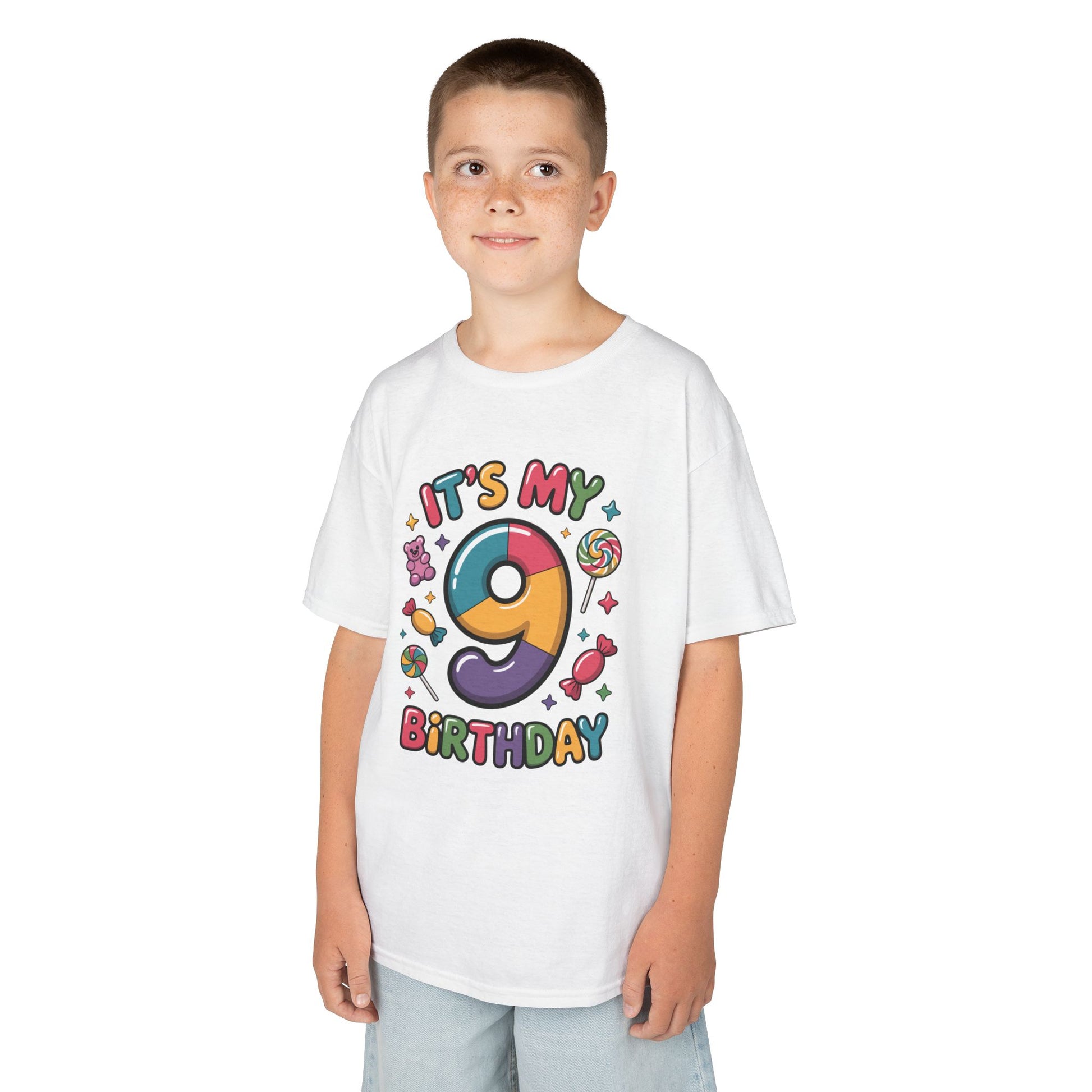 “Boy wearing white ‘It’s My 9th Birthday’ rainbow 9 and candy graphic tee, front view.”
