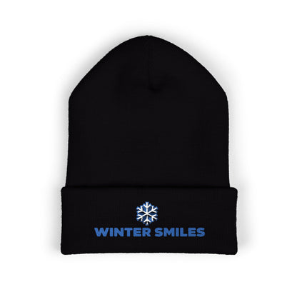 Black beanie with 'Winter Smiles' text and snowflake logo on a white background. Blue embroidered “Winter Smiles” snowflake design on cuffed winter beanie
