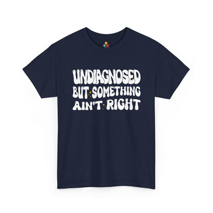 “Teezoca Undiagnosed But Something Ain’t Right shirt, retro white lettering mental health humor graphic, navy blue tee, flat lay.”​

